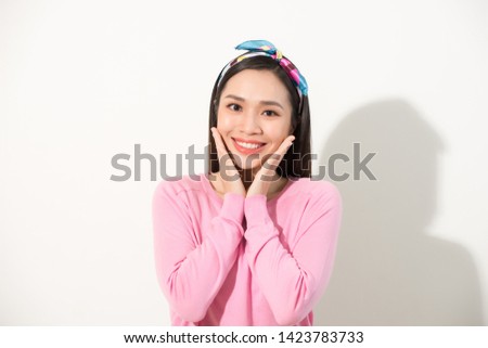 Cute asian presenting her face with hands touching face in v shape, portrait, skincare and cosmetic concept, pink shirt, white background