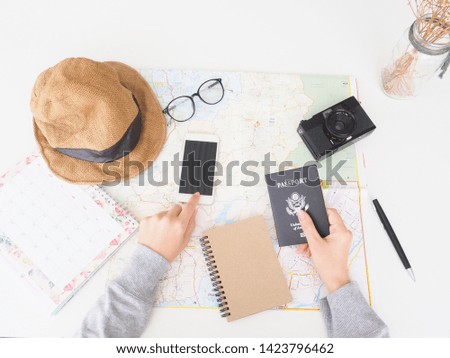 top view travel concept with, map, passport, smartphone, action camera and on white background with copy space, Tourist essentials.