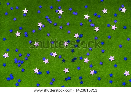 
Blue and silver sparkles stars on a bright green background. Festive concept. Magic light. Vibrant abstract background. Star shape