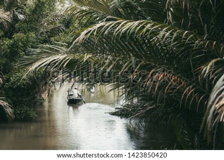 Rowing boat in narrow canal in Mekong Delta Vietnam