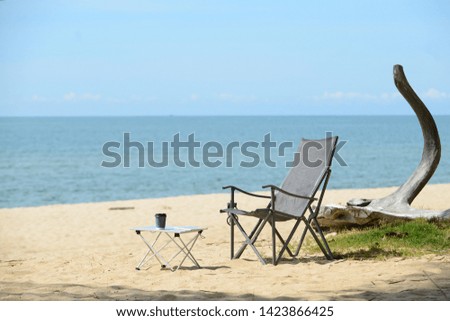 Chair and table on the beach. Time for a vacation.
