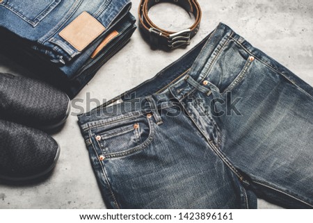 many blue jeans on concrete background. men fashion denim jeans.