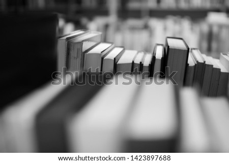 Books on shelf in library, black and white photography