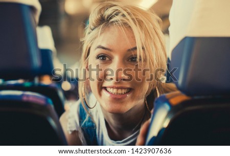 Young woman traveling looking out the window while sitting in the train. Smile woman. Fashion photo. Travel. Vacation. 
