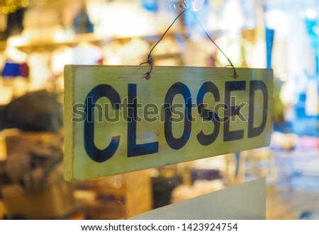 Closed sign in a shop showroom with selective focus and blurred background