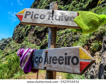 Signboard on the touristic trail Pico Ruivo- Pico Areeiro with two warm hats on it. Madeira. Portugal.