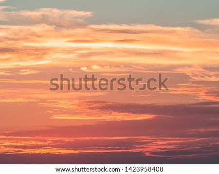 Abstract close up of a dramatic sunset sky. Pastel colors with orange, pink, red and yellow clouds