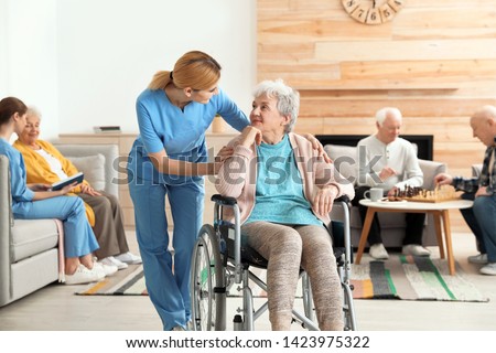 Nurses assisting elderly people at retirement home Royalty-Free Stock Photo #1423975322