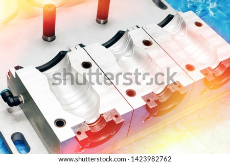 A closeup of an aluminum mold template for making plastic bottles in a factory. Industrial background. Royalty-Free Stock Photo #1423982762