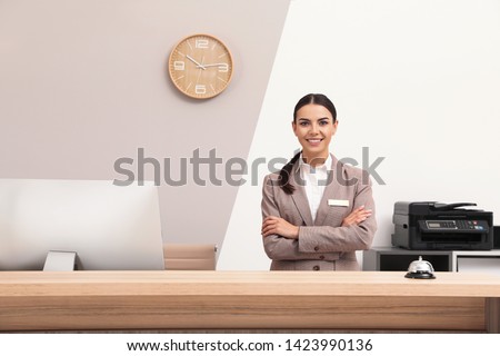 Portrait of receptionist at desk in modern hotel Royalty-Free Stock Photo #1423990136