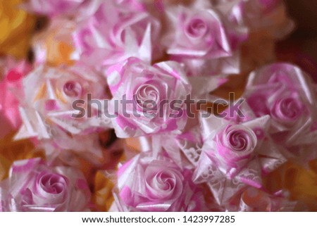 Roses are made for ribbon. Coin fold paper for give alms to make merit in Thai religions traditional.