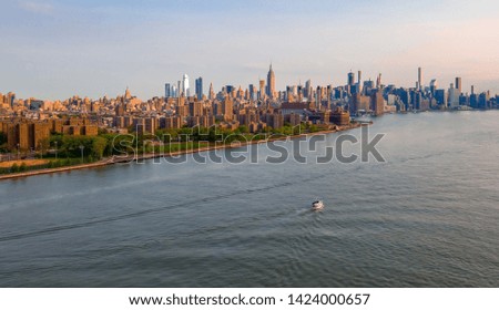 New York City skyline with urban skyscrapers at sunrise over Manhattan island.