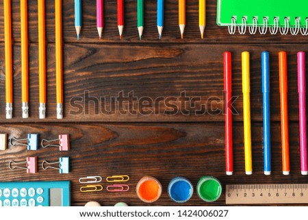 Flat lay composition with school supplies on wooden background, space for text