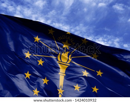waving flag State of Indiana close up against blue sky