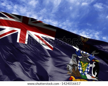 waving flag of South Georgia and the South Sandwich Islands close up against blue sky