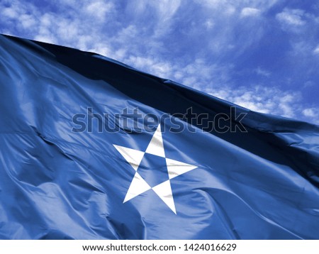 waving flag of Somalia close up against blue sky