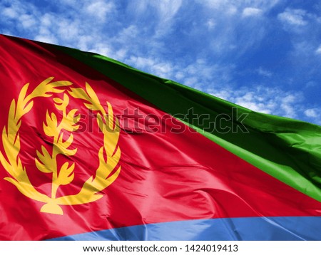 waving flag of Eritrea close up against blue sky