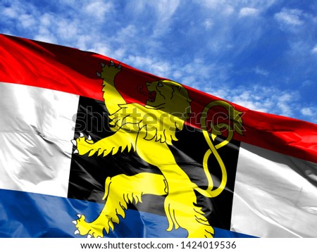waving flag of Benelux close up against blue sky