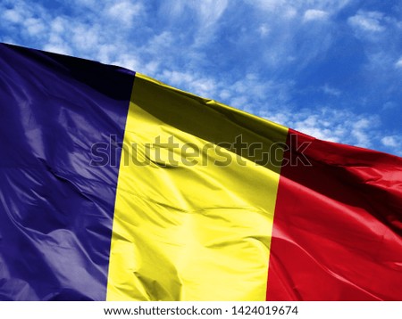waving flag of Romania close up against blue sky