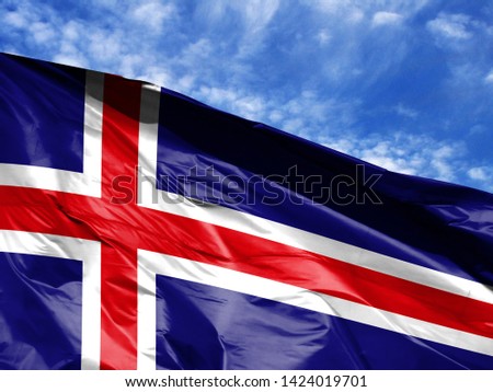waving flag of Iceland close up against blue sky