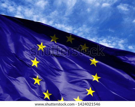 waving flag of European Union close up against blue sky