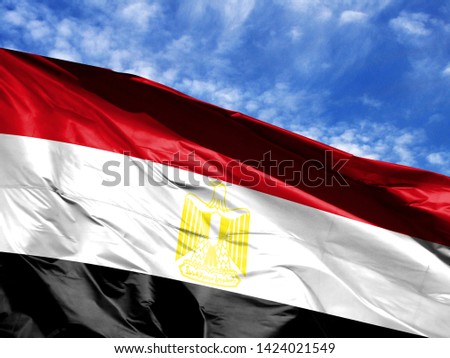 waving flag of Egypt close up against blue sky