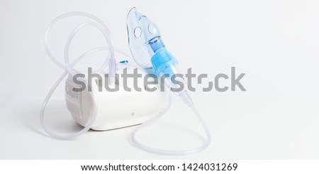 Medical equipment for inhalation with respiratory mask, nebulizer on a white background. Respiratory medicine. Asthma breathing treatment. Bronchitis, asthmatic health equipment Royalty-Free Stock Photo #1424031269