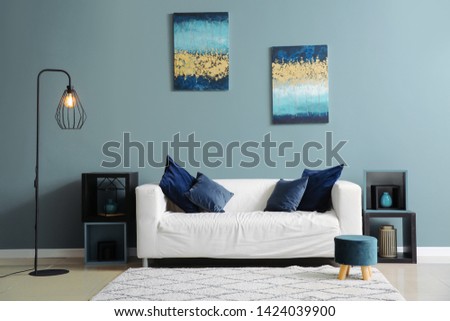 Interior of room with comfortable sofa near color wall