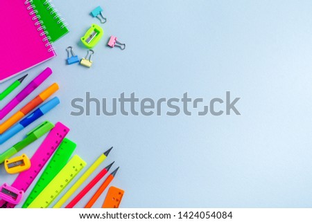 Frame of different stationery on light blue background, flat lay. Space for text. Back to school concept.