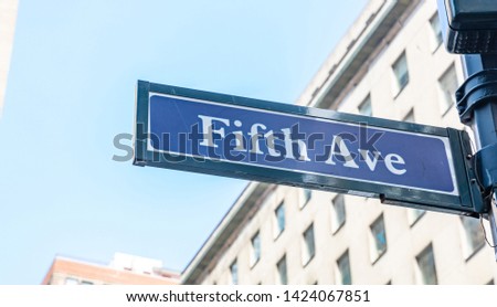 Fifth ave street sign, Manhattan New York downtown. Blue sign on blur buildings facade and blue sky background,