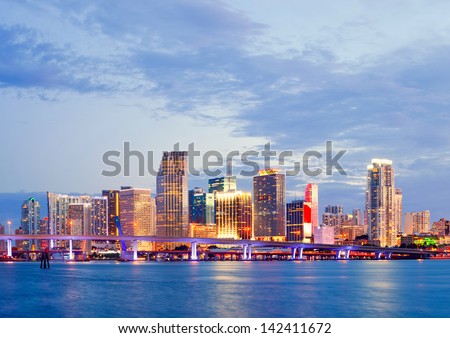 CIty of Miami Florida, summer sunset panorama with colorful illuminated business and residential buildings and bridge on Biscayne Bay