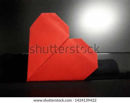 red heart paper on a black background