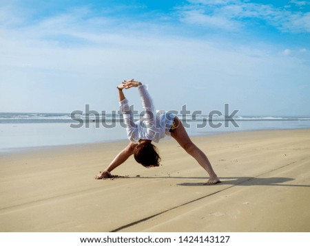 Beautiful girl is engaged in yoga by the ocean