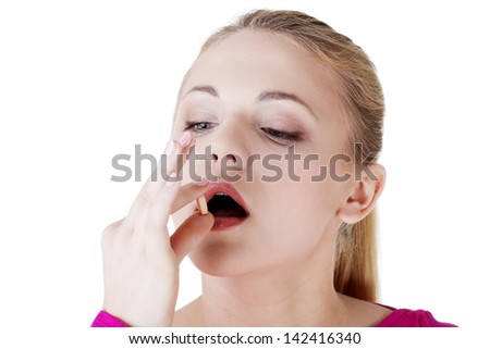 Blond woman taking pill, isolated on white.