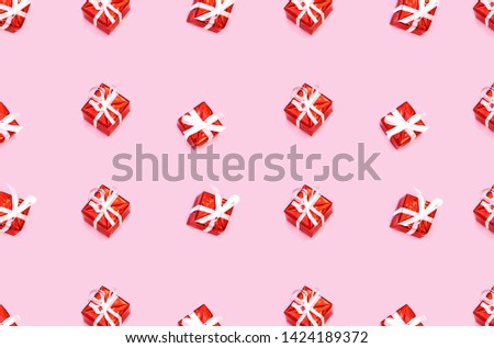 Pattern made from Christmas gift boxes isolated on pink backhround. Festive concept.