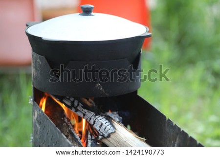 big pot for outdoor cooking on fire at summer in the garden