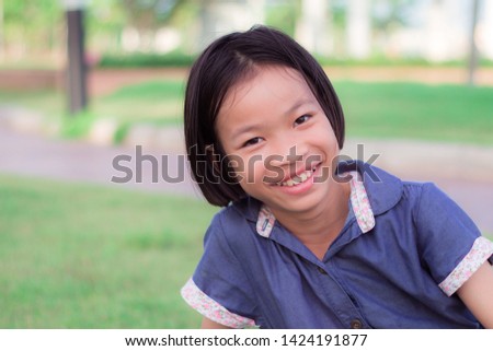 closeup portrait child smile. asian cute little girl in park at thiland