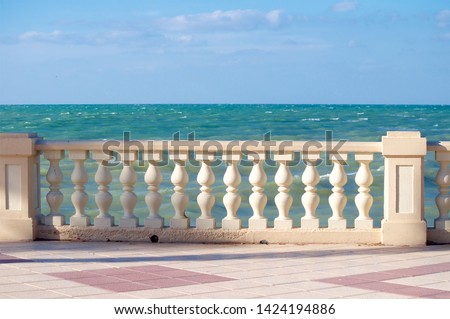 walk along the promenade with a parapet on a Sunny windy day by the ocean Royalty-Free Stock Photo #1424194886