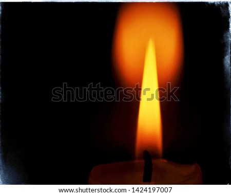 a picture of a candle with a reflection of the flame
