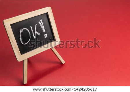 mini blackboard on desk redbackground with personalized message "OK!"