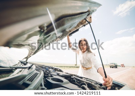 In a young beautiful woman's car was broken during the trip, she tries to call the tow truck