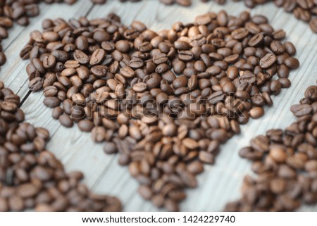 roasted coffe beans on the grey background, coffe in hands, heart from coffe  