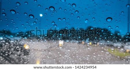 Water droplets on a partially tinted window.
