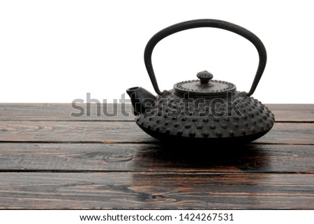 Black Iron Teapot on Wooden Background