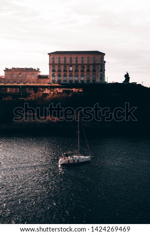 A boat sailing on a river in Marseille, France with amazing architecture in the background