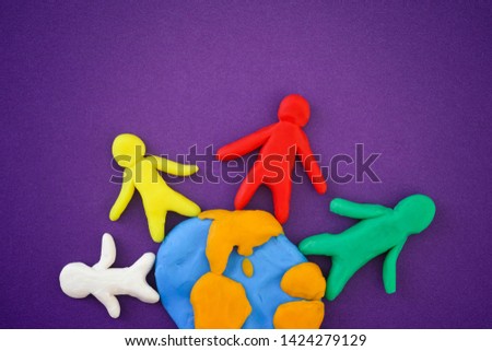 Multiethnic group of people around the world. Concept image. People and Earth are made out of play clay (plasticine). Close up.