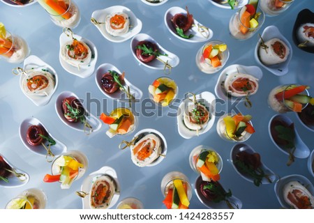 Fresh snacks fish meat, tuna, greens on table in restaurant. Top view.  Catering guest meals during event. Quick mini snacks dish. Chopped sticks of vegetables sauce. Rolls cheese, red fish caviar.