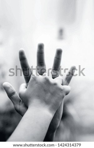 Child hand comparing her hand with her father shot with blurred bokeh background and the concept of Father’s day ( 16th June).