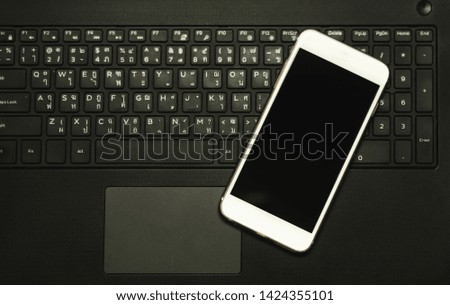 Social network and internet connection concept, Smart phone mobile on computer keyboard dark filter background