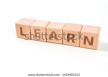 word LEARN on wood cube dices on white background.